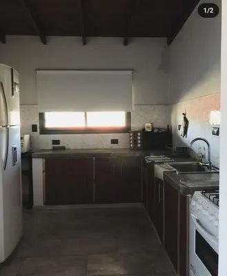 a kitchen with brown cabinets and a white refrigerator at Casa en Santa Rosa de Calamuchita in Santa Rosa de Calamuchita
