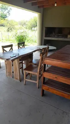 a wooden table and chairs with a table and a bench at Casa en Santa Rosa de Calamuchita in Santa Rosa de Calamuchita