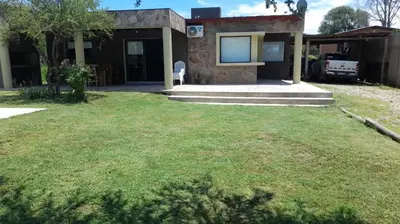 a house with a lawn in front of it at Casa en Santa Rosa de Calamuchita in Santa Rosa de Calamuchita