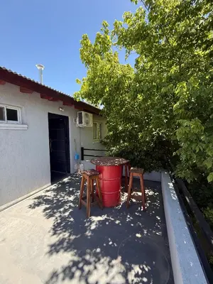 a patio with two stools and a red bucket at Romedeptos II in Merlo