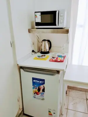 a small refrigerator with a microwave on top of it at Habitacion con baño privado in Cordoba