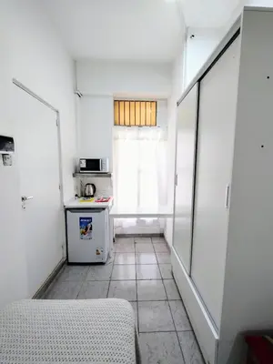 a small kitchen with a refrigerator and a window at Habitacion con baño privado in Cordoba
