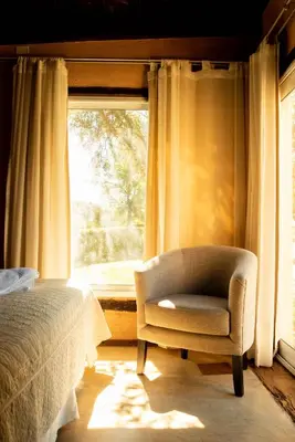 a bedroom with a bed and a chair and a window at Brisas de Chacras in San Javier