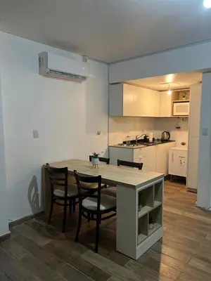 a kitchen with a table and chairs in a room at Departamento Bolivar in Cordoba