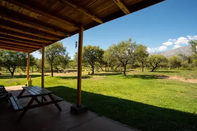 a porch with a picnic table and a field of grass at La Comarca in San Javier
