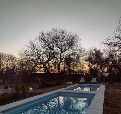 a swimming pool in a yard with a sunset in the background at La Comarca in San Javier