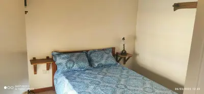 a bedroom with a bed with blue comforter and pillows at SARA COMPLEJO in Mina Clavero