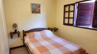 a bedroom with a bed with a plaid blanket at SARA COMPLEJO in Mina Clavero