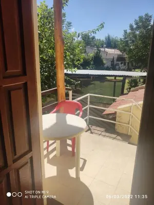a white table and a red chair on a balcony at SARA COMPLEJO in Mina Clavero