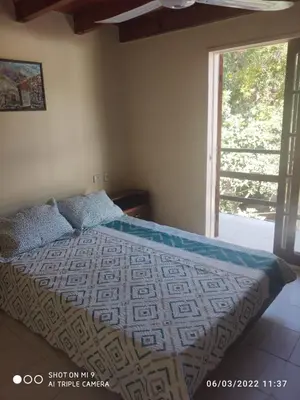 a bedroom with a bed with a large window at SARA COMPLEJO in Mina Clavero