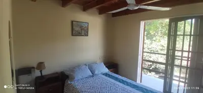 a bedroom with a bed with blue pillows and a window at SARA COMPLEJO in Mina Clavero