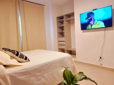 a room with a bed and a tv on the wall at Casa Roque Funes, ubicado en Cerro de las Rosas Córdoba, Ofrece, Asador, Pileta, Cercanias, Estadio Kempes, aeropuerto Ambrosio Taravella, Orfeo Superdomo, Sanatorio Allende, Casa con 2 departamentos individuales y áreas comunes in Cordoba