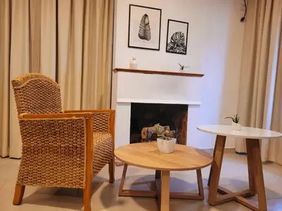 a living room with a table and a chair and a fireplace at Casa Roque Funes, ubicado en Cerro de las Rosas Córdoba, Ofrece, Asador, Pileta, Cercanias, Estadio Kempes, aeropuerto Ambrosio Taravella, Orfeo Superdomo, Sanatorio Allende, Casa con 2 departamentos individuales y áreas comunes in Cordoba