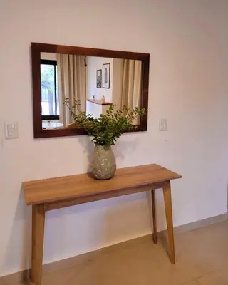 a vase sitting on a table under a mirror at Casa Roque Funes, ubicado en Cerro de las Rosas Córdoba, Ofrece, Asador, Pileta, Cercanias, Estadio Kempes, aeropuerto Ambrosio Taravella, Orfeo Superdomo, Sanatorio Allende, Casa con 2 departamentos individuales y áreas comunes in Cordoba
