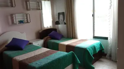 a room with two beds with green and brown at Casa LA SULISA in Merlo