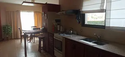a kitchen with a sink and a counter with a table at Casa LA SULISA in Merlo