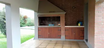 a kitchen with wooden cabinets and a brick wall at Casa LA SULISA in Merlo