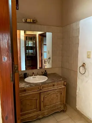 a bathroom with a sink and a mirror at Estancia Urbana Casa de Huéspedes in Río Cuarto