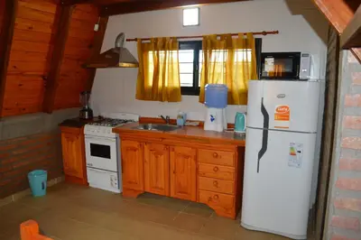 a kitchen with a white refrigerator and a sink at Complejo de Cabañas Valentino in Embalse