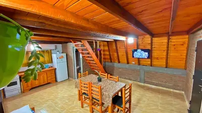 a dining room with a table and a staircase in a kitchen at Complejo de Cabañas Valentino in Embalse