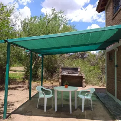 a table and chairs under a green canopy at Cabaña Providencia in Cortaderas
