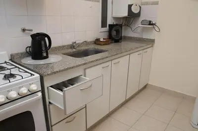 a white kitchen with a sink and a stove at Malanca - Nueva Córdoba in Cordoba