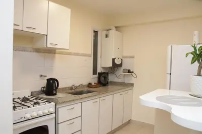a kitchen with white cabinets and a stove and a sink at Malanca - Nueva Córdoba in Cordoba