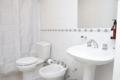 a white bathroom with a toilet and a sink at Malanca - Nueva Córdoba in Cordoba