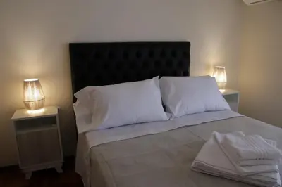 a bed with white pillows and two night stands at Malanca - Nueva Córdoba in Cordoba