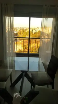 a room with a glass table and a chair and a window at Moderno dpto 1 dorm cerca de hospitales y terminal 4 personas in Cordoba