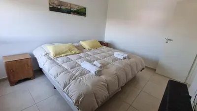 a large bed in a bedroom with two pillows at Moderno dpto 1 dorm cerca de hospitales y terminal 4 personas in Cordoba