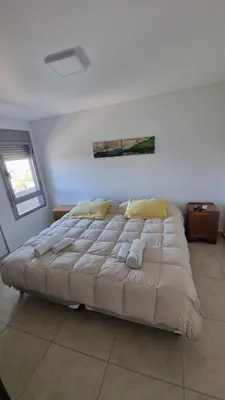 a large bed in a white room with at Moderno dpto 1 dorm cerca de hospitales y terminal 4 personas in Cordoba
