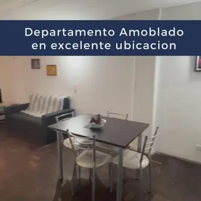 a table and chairs in a living room with a couch at Monoambiente Amoblado in Cordoba