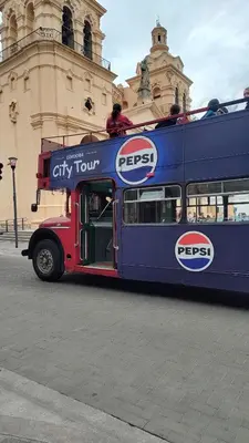 a double decker bus driving down the street at Monoambiente Amoblado in Cordoba
