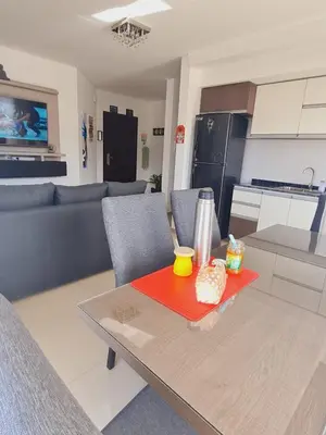 a living room with a table and a kitchen at Edificio Leonardo 6to piso in Villa Carlos Paz