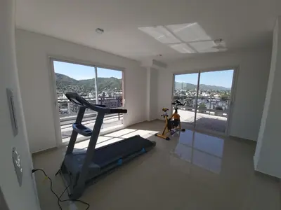 a room with a gym with a treadmill and windows at Edificio Leonardo 6to piso in Villa Carlos Paz