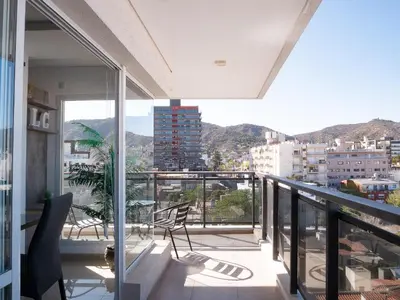 a balcony with chairs and a view of a city at Edificio Leonardo 6to piso in Villa Carlos Paz