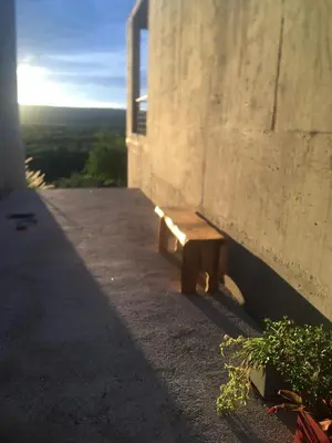 a wooden bench sitting on the side of a building at Sol Suites in Villa Cura Brochero