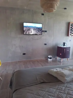 a bedroom with a flat screen tv on the wall at Sol Suites in Villa Cura Brochero