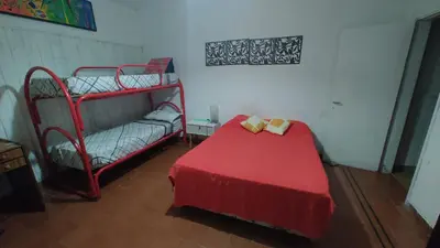 a bedroom with two bunk beds and a red bed at Habitación Privada en casa compartida, para mujeres, parejas, grupo mixto in Cordoba