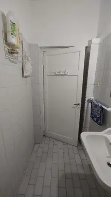 a bathroom with a white door and a sink at Habitación Privada en casa compartida, para mujeres, parejas, grupo mixto in Cordoba