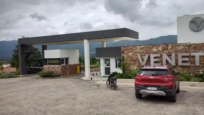 a red car parked in front of a garage at Veneto Village, Complejo Vacacional in Villa Parque Siquiman