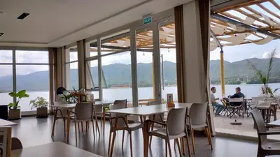a restaurant with tables and chairs and a view of the water at Veneto Village, Complejo Vacacional in Villa Parque Siquiman