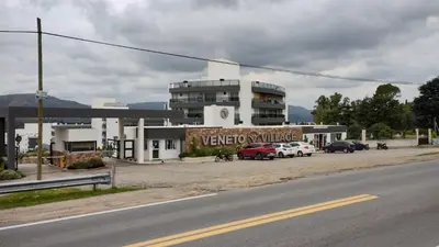 a parking lot with cars parked in front of a building at Veneto Village, Complejo Vacacional in Villa Parque Siquiman