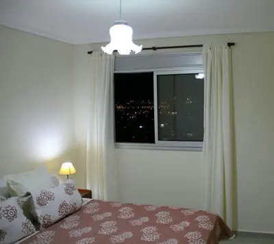 a bedroom with a window with a view of a city at Hotel Cardiólogico in Cordoba