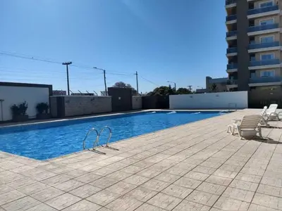 a swimming pool with chairs next to a building at Hotel Cardiólogico in Cordoba