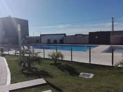 a swimming pool with palm trees in front of a building at Hotel Cardiólogico in Cordoba