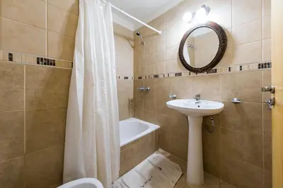 a bathroom with a sink and a toilet and a bath tub at Viaggiato Larrañaga II in Cordoba