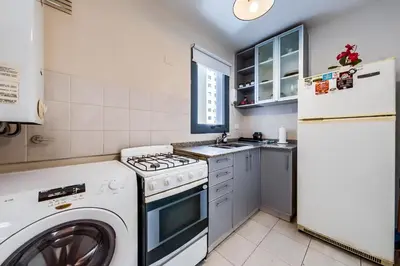 a kitchen with a washing machine and a refrigerator at Viaggiato Larrañaga II in Cordoba