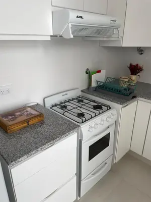 a white stove top oven in a kitchen at Departamento céntrico y espacioso en Río Cuarto. in Río Cuarto